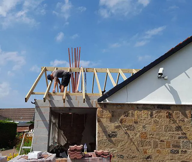 Work being done on a roof being added to an extension 